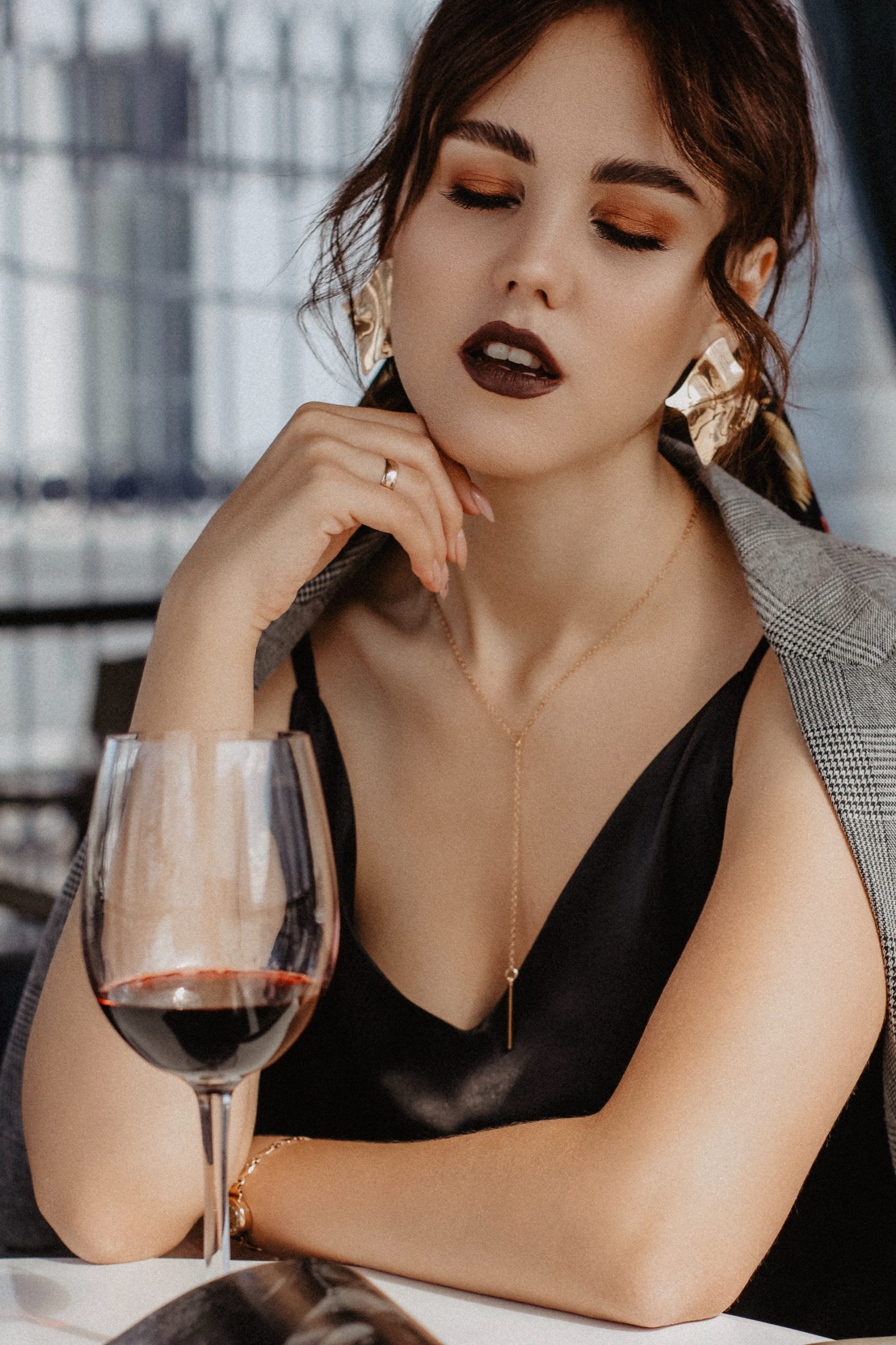 slurring young woman chilling in front of a glass of red wine